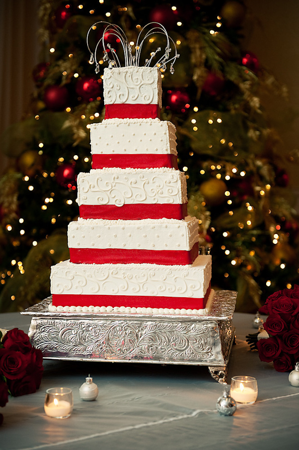 White five tier square wedding cake with red borders on a silver cake stand - photo by Houston based wedding photographer Adam Nyholt 